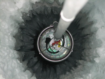 Versenken eines IceCube-Moduls am Südpol (Credit: DESY) Versenken eines IceCube-Moduls am Südpol, Blick in das Bohrloch. (Credit: DESY)