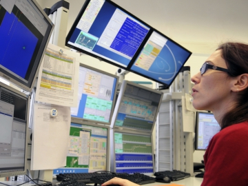 Doktorandin im Rechnerlabor bei DESY (Credit: DESY) Eine Doktorandin im Rechnerlabor bei DESY schaut auf diverse Computerbildschirme