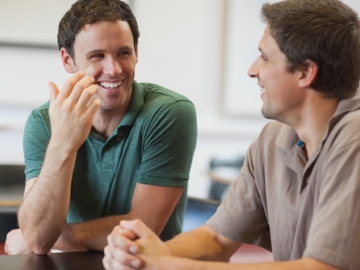 (Copyright: wavebreakmedia/shutterstock.com) Zwei junge Männer führen ein Gespräch