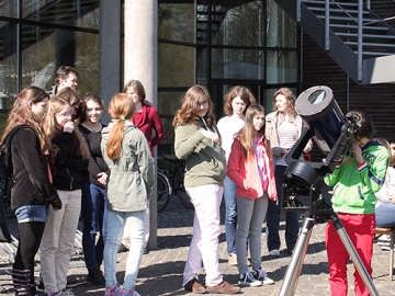 Girls' Day/Zukunftstag Brandenburg am AIP (Credit: AIP) Potsdam: Eine Gruppe von Schülerinnen steht um ein Teleskop, eine Schülerin schaut hindurch